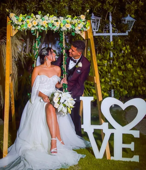 Pareja celebrando en montaje floral de Casita de Chuao
